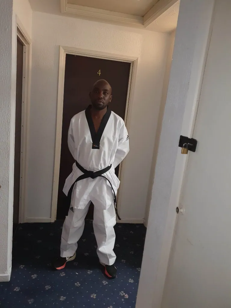 Taekwondo black-belt athlete standing in uniform